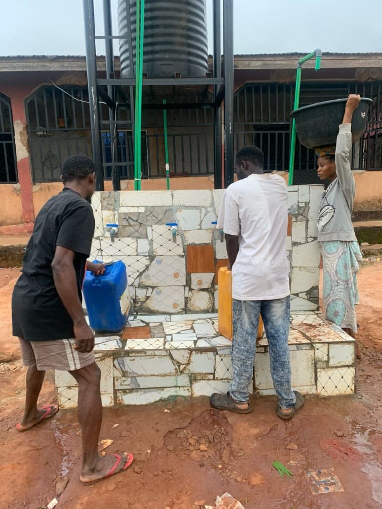 Residents filling containers at the Ohovbe community taps